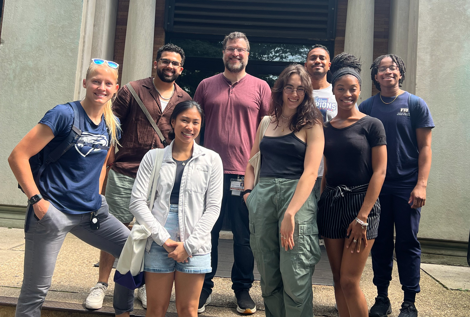 A smiling group of people in front of a building