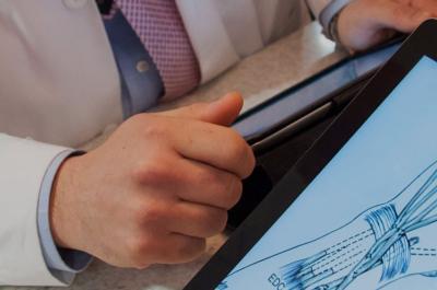 Doctor Looks at Image of Hand on Tablet Screen