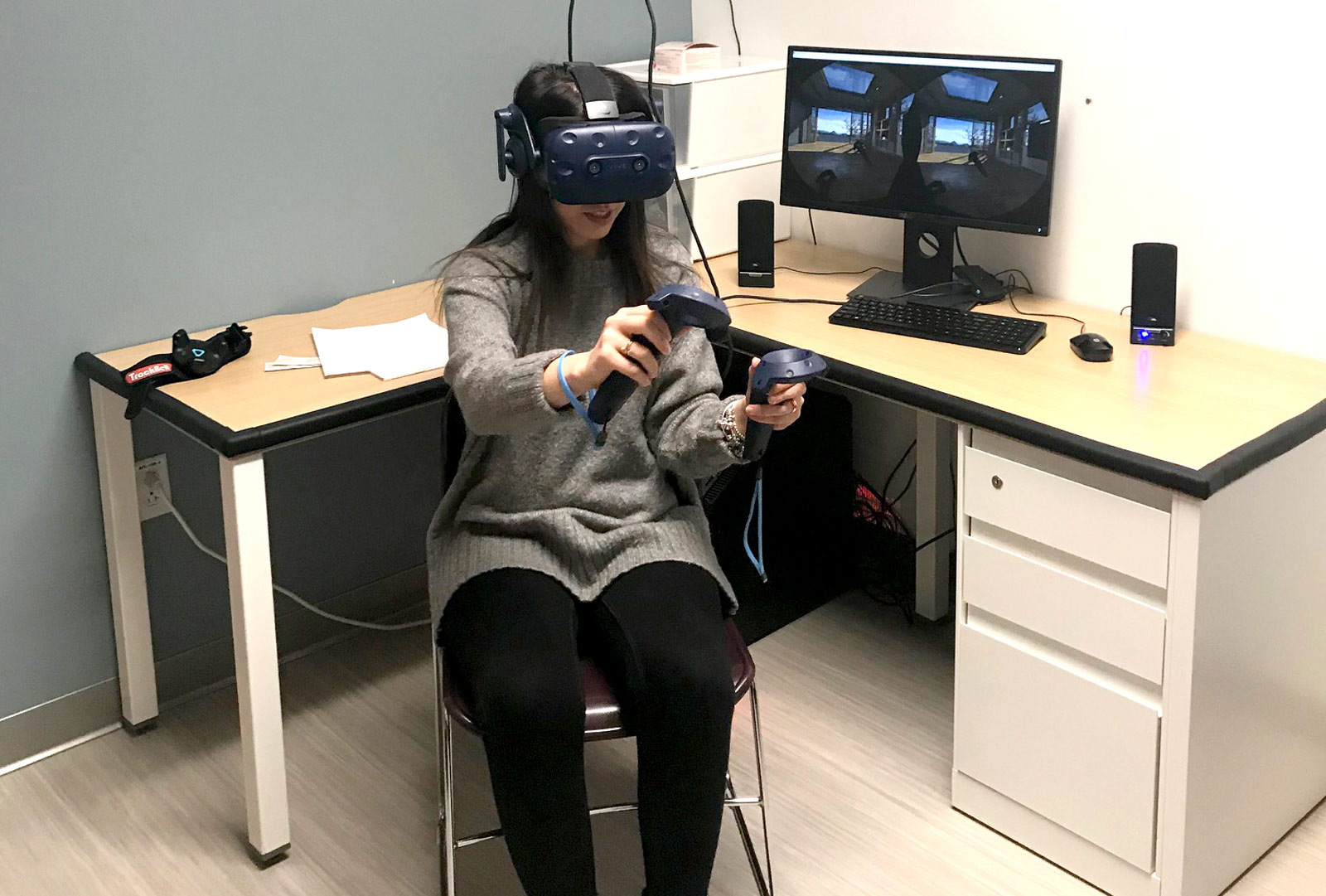 Patient wearing headset with handheld controllers experiences VR