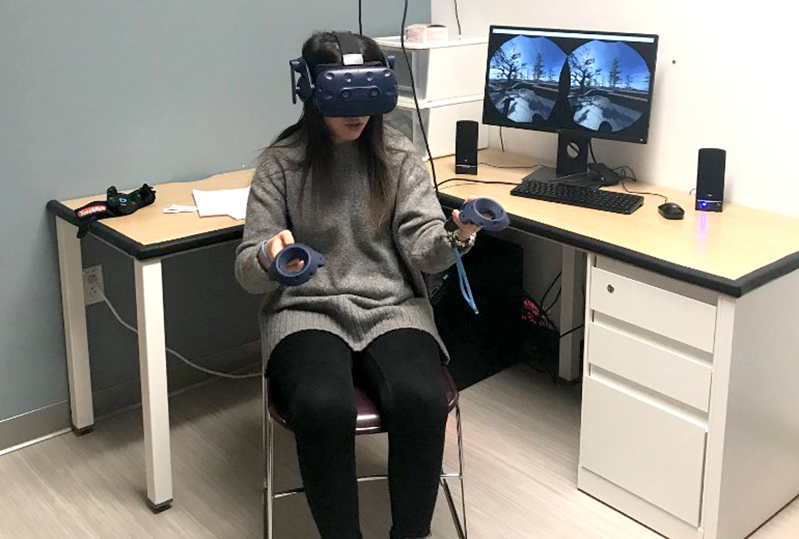 Woman wearing virtual reality headset uses handheld controllers