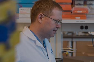 Dr. George Miller Speaks with Colleague in Lab