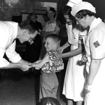 Black and White Image of Nurses and Doctor Treating Young Boy