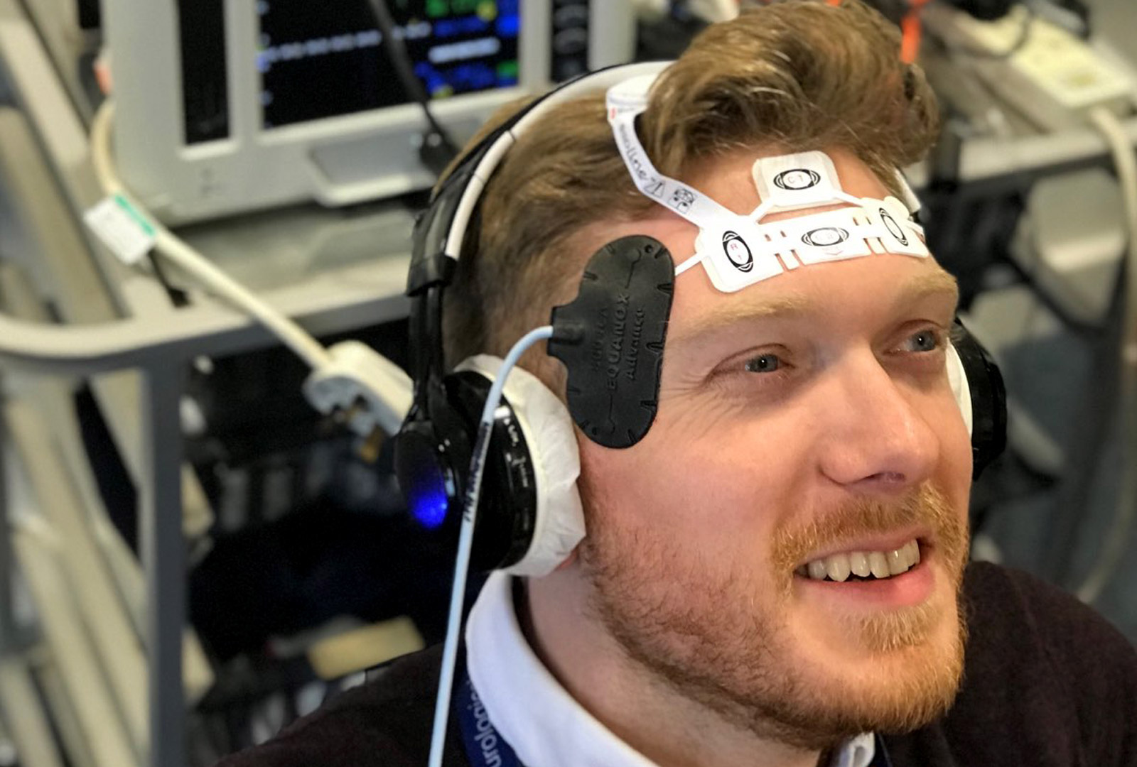  člen týmu v Anglii demonstruje zařízení pro monitorování mozku