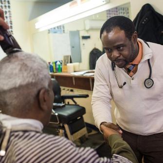 Dr. Joseph Ravenell Shakes Man’s Hand in Barbershop