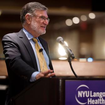 Dr. Steven Abramson Speaks at a Podium